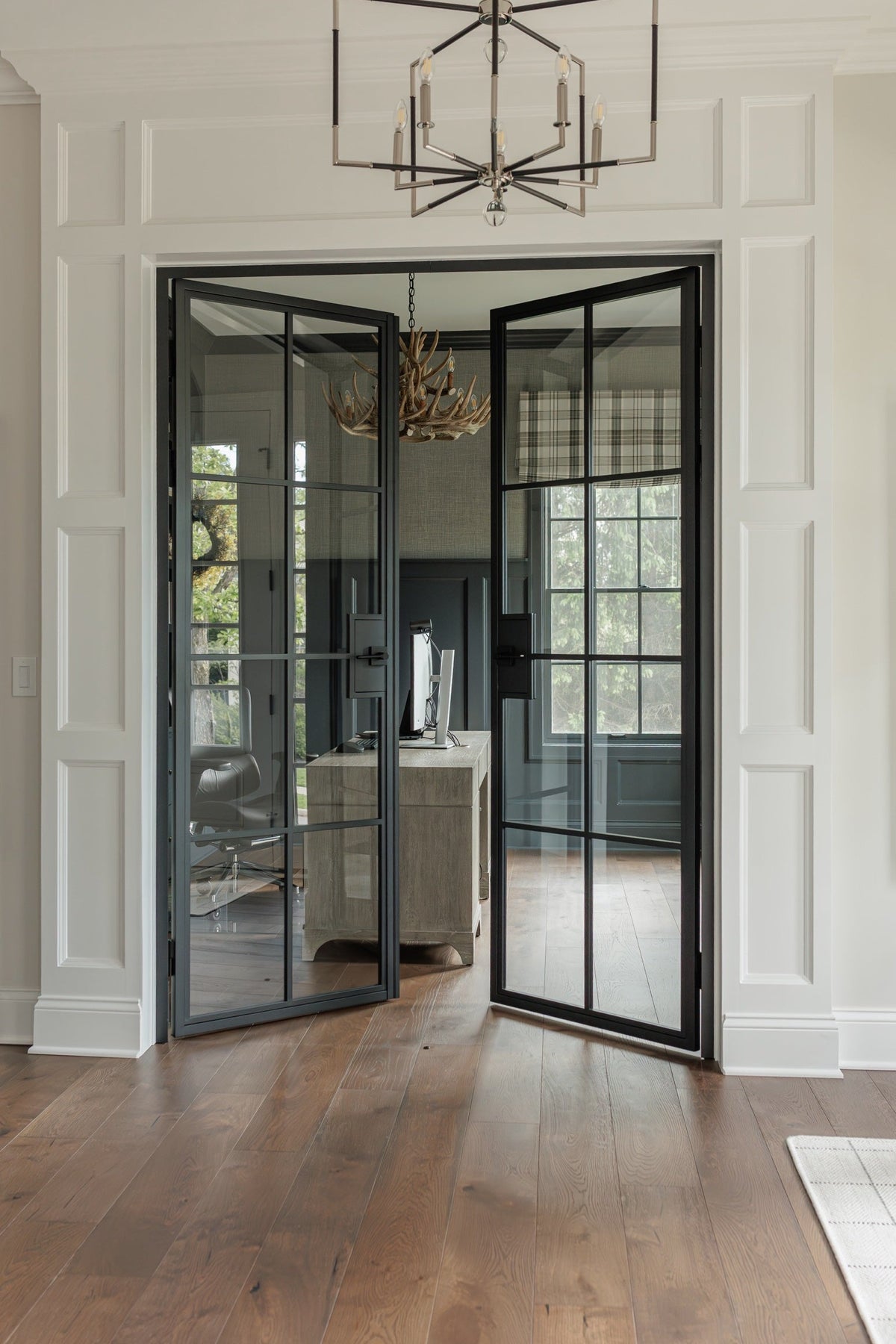 8 Lite steel French double door with clear glass, both leaves open into a home office, white panelled hallway