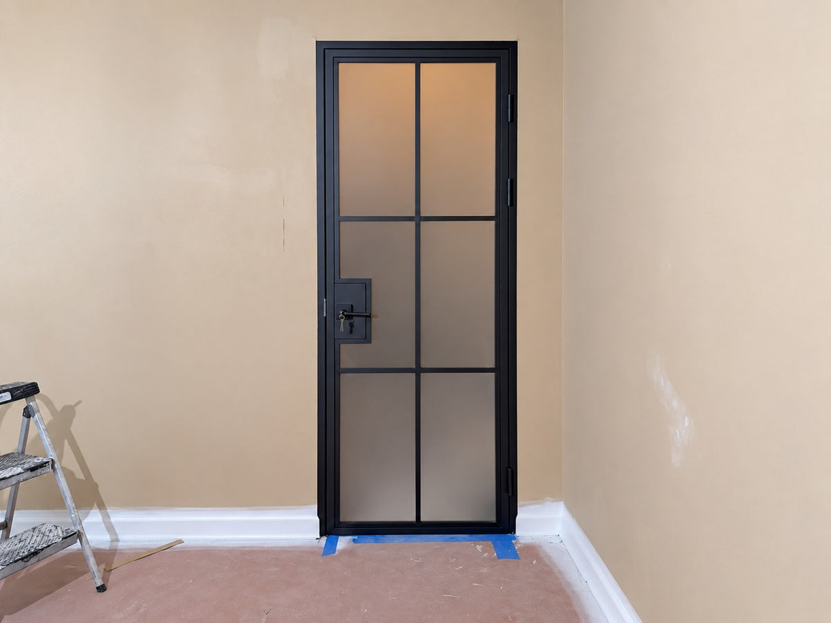 After: installed black steel door with frosted glass panels
