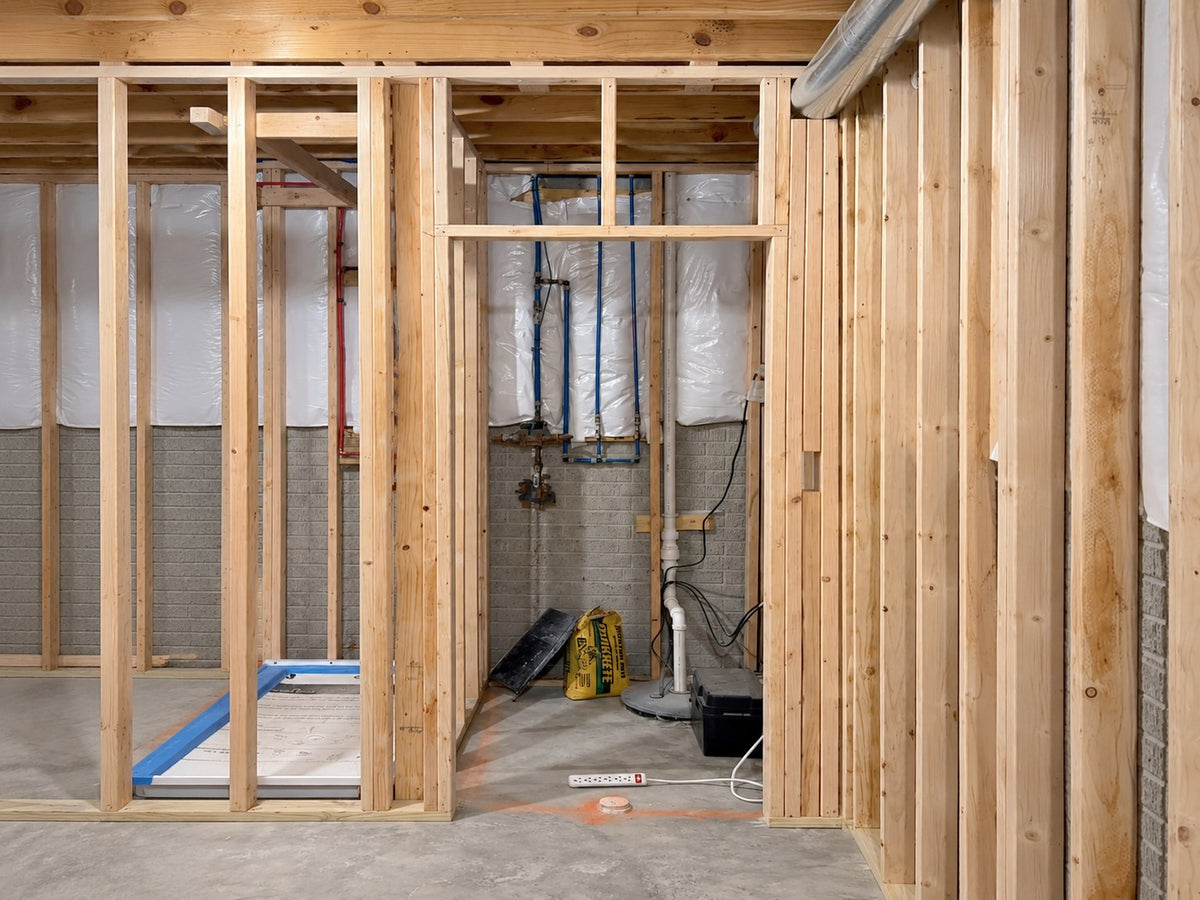 Before: framed basement room with open wall studs, ready for a new door